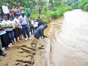 Le maire Frédéric Harelimana et l'honorable Abbas Mukama  déposant les fleurs dans la rivière de Rubyiro (Photo Bahuwiyongera)